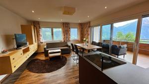 a living room with a table and chairs and a television at Berggasthaus Steinerkogl in Brandberg