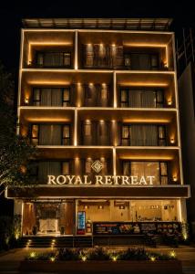 a hotel building with a royal retreat sign at night at Hotel Royal Retreat in Shirdi