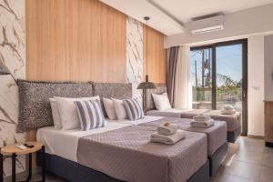 a hotel room with two beds and a couch at Prasonisi Lighthouse Studios in Prasonisi