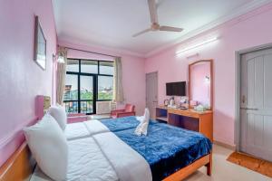 a bedroom with a large bed with a blue blanket at Margao Residency in Madgaon