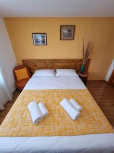 a bedroom with a large bed with two towels on it at Casa Cami in Jurilovca