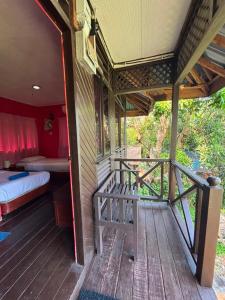 a porch of a house with a bed and a bedroom at Nazri's Place 2 in Tioman Island