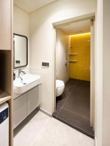 a bathroom with a white toilet and a sink at Coliwoo Midtown - CoLiving in Singapore