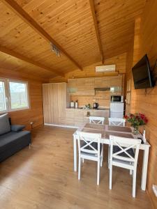 a kitchen and living room with a table and chairs at Domki Me Mazury in Giżycko