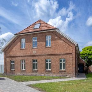 a large brick house with a red roof at Gulfhof bei Kletzsch Apartments & Ferienwohnungen in Großefehn Ostfriesland in Großefehn 