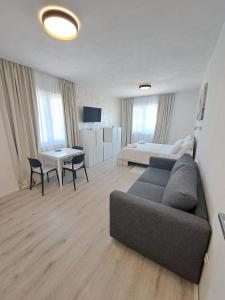 a living room with a couch and a bed and a table at Paulina Harmony Rooms in Seget Vranjica