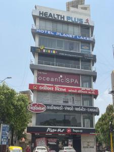 a tall building with signs on the side of it at Hotel Planet Lake in Ahmedabad