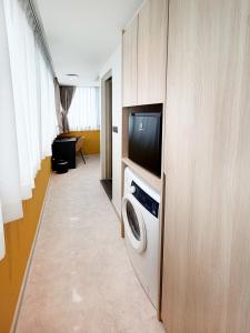 a living room with a washing machine and a tv at Coliwoo Midtown - CoLiving in Singapore