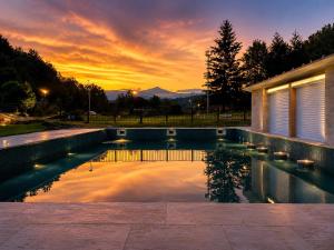 a swimming pool with a sunset in the background at ELS OCELLS Apartaments i Cases Rurals in Camprodon