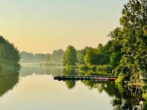 a boat on a river with trees in the background at Apartment am Freitagsbach in Celle