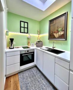 a kitchen with white cabinets and a sink at Apartment am Freitagsbach in Celle +11 photos