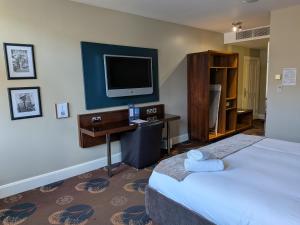 a hotel room with two beds and a television at Queens Hotel Belfast in Belfast
