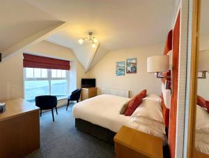 ein Hotelzimmer mit Bett und Schreibtisch in der Unterkunft Caerwylan Hotel in Criccieth