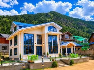 a large house with a mountain in the background at The Frozen Leaf in Pahalgām