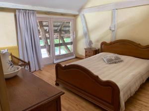 a bedroom with a large bed and a window at Ferme Alsacienne in Soppe-le-Haut