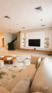 a living room with a couch and a flat screen tv at Paradise in Al Khīrān