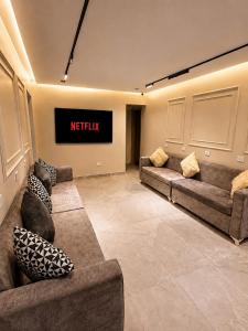 a waiting room with couches and a television on the wall at Landmark Hostel Cairo in Cairo