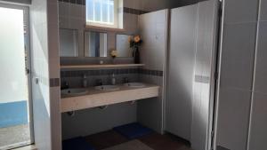 a bathroom with two sinks and a mirror at CCCA Monte Loureiro in Raposeira