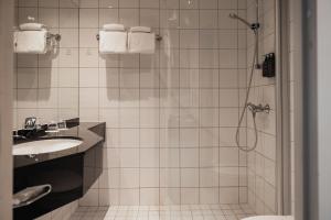 a bathroom with a shower and a sink at Home Hotel Aurora in Tromsø +36 photos