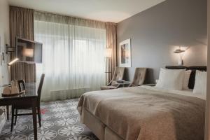 a hotel room with a bed and a table and chairs at Home Hotel Aurora in Tromsø