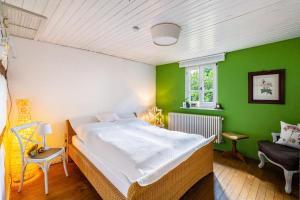 a bedroom with a bed and a green wall at Heimat Liebe_Scialla in Herbolzheim