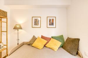 a room with a couch with colorful pillows at La Pau de Portbou 2 in Portbou