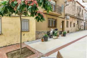 a tree on a sidewalk in front of a building at La Pau de Portbou 2 in Portbou
