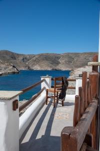 a wooden bench sitting on the edge of a balcony overlooking the ocean at Aegean Whisper Koumelas in Mamádhos