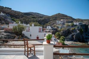 a chair on a balcony with a view of a city at Aegean Whisper Koumelas in Mamádhos