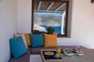 a living room with a couch with a view of the ocean at Aegean Whisper Koumelas in Mamádhos