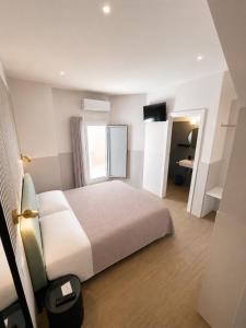 a bedroom with a white bed and a window at B&B Luna Rossa in Altamura