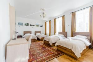 a room with four beds in it with a rug at Nazy's Guest House in Joqolo +55 photos