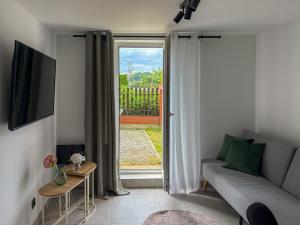 a living room with a couch and a sliding glass door at Apartamenty Piotrowice in Piotrowice