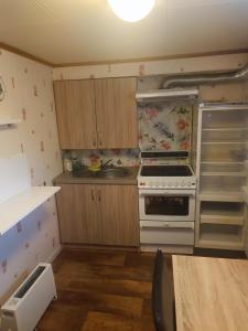 a small kitchen with a stove and a refrigerator at Aurora appartmens in Senja