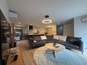 a living room with a couch and a table at Koyuki Kimobetsu in Abuta