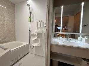 a bathroom with a sink and a shower and a mirror at Koyuki Kimobetsu in Abuta +10 photos