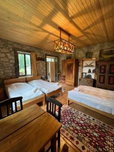 a bedroom with two beds and a wooden ceiling at Mushkudiani Manor in Mestia