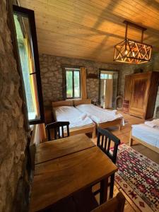 a bedroom with two beds and a table in a room at Mushkudiani Manor in Mestia