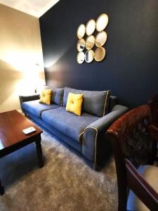 a living room with a blue couch and a table at Friars Wynd Guest Rooms in Stirling