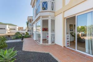 a house with large glass doors and a patio at Piccola Oasi Corralejo in Corralejo