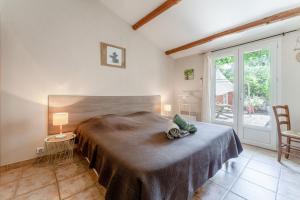 a bedroom with a large bed and a balcony at Chambres D'hôtes Les Seignerolles in Pernes-les-Fontaines