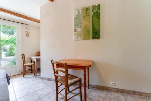 a dining room with a wooden table and chairs at Chambres D'hôtes Les Seignerolles in Pernes-les-Fontaines