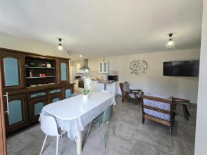 a kitchen and dining room with a white table and chairs at Chez eugénie in Génis +8 photos