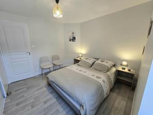 a bedroom with a bed and two chairs in it at Chez eugénie in Génis