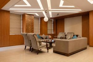 a lobby with chairs and a couch and a table at Landmark, Rewa - AM Hotel Kollection in Rewa +28 photos