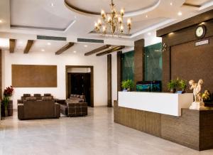 a lobby of a hotel with a reception desk and chairs at Landmark, Rewa - AM Hotel Kollection in Rewa