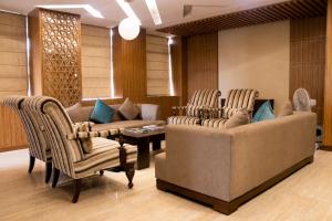 a living room with two couches and a table and chairs at Landmark, Rewa - AM Hotel Kollection in Rewa