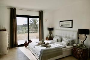 a bedroom with a large bed and a large window at Ocean Blues in Cala Santanyi +17 photos