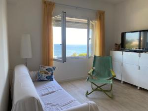 a living room with a couch and a chair and a television at Il Piccolo Cristallo sul Mare in Santa Marinella