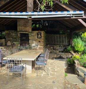 a table and chairs in front of a stone wall at Le Relais de Saint Germain in Saint-Germain-les-Belles
